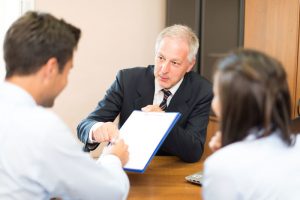a couple being handed paperwork to sign