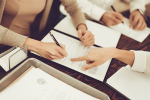 Husband and Wife Signing Document with Lawyer