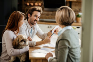 young happy couple with a dog and their financial advisor