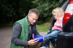 father putting wellington boot on child