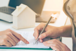 client signs home loan or divorce document with real estate property agent or lawyer